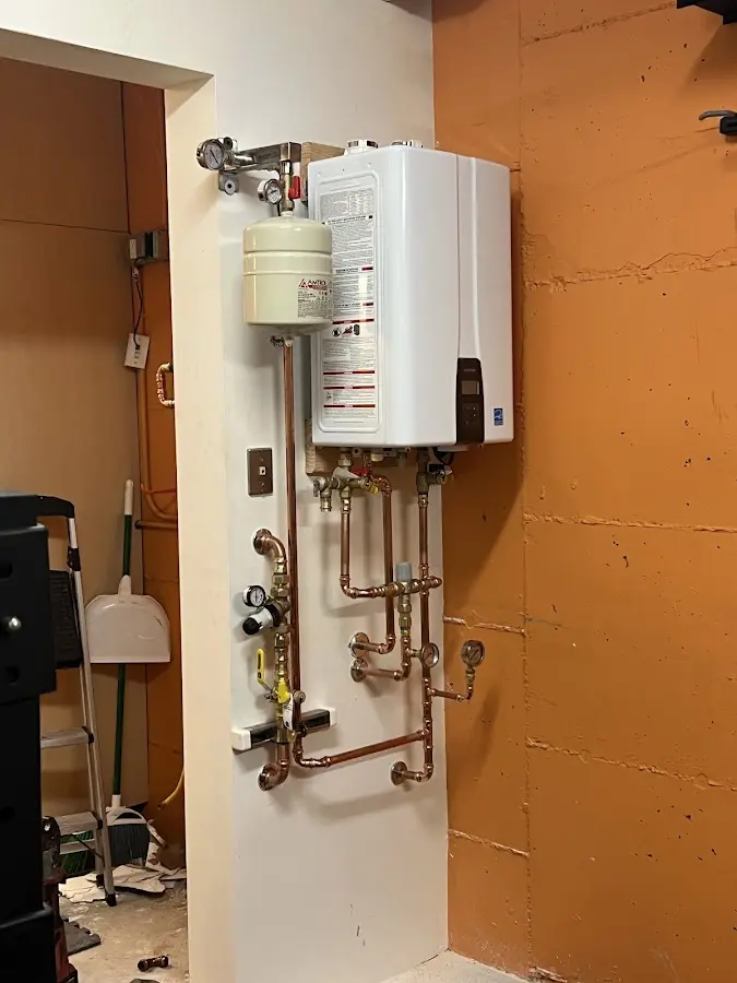 Plumbing technician inspecting water heater connections in Siesta Key